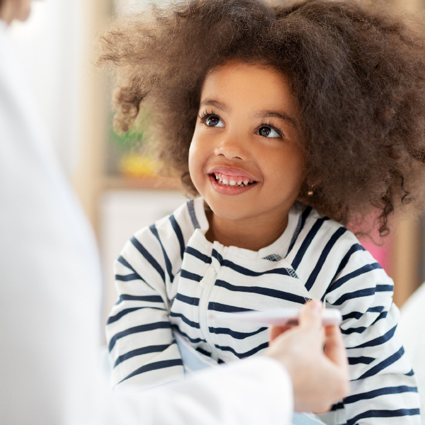 An office corner featuring a vibrant nature mural of a rocky river landscape, green walls, and a black chair. Natural light from a window.